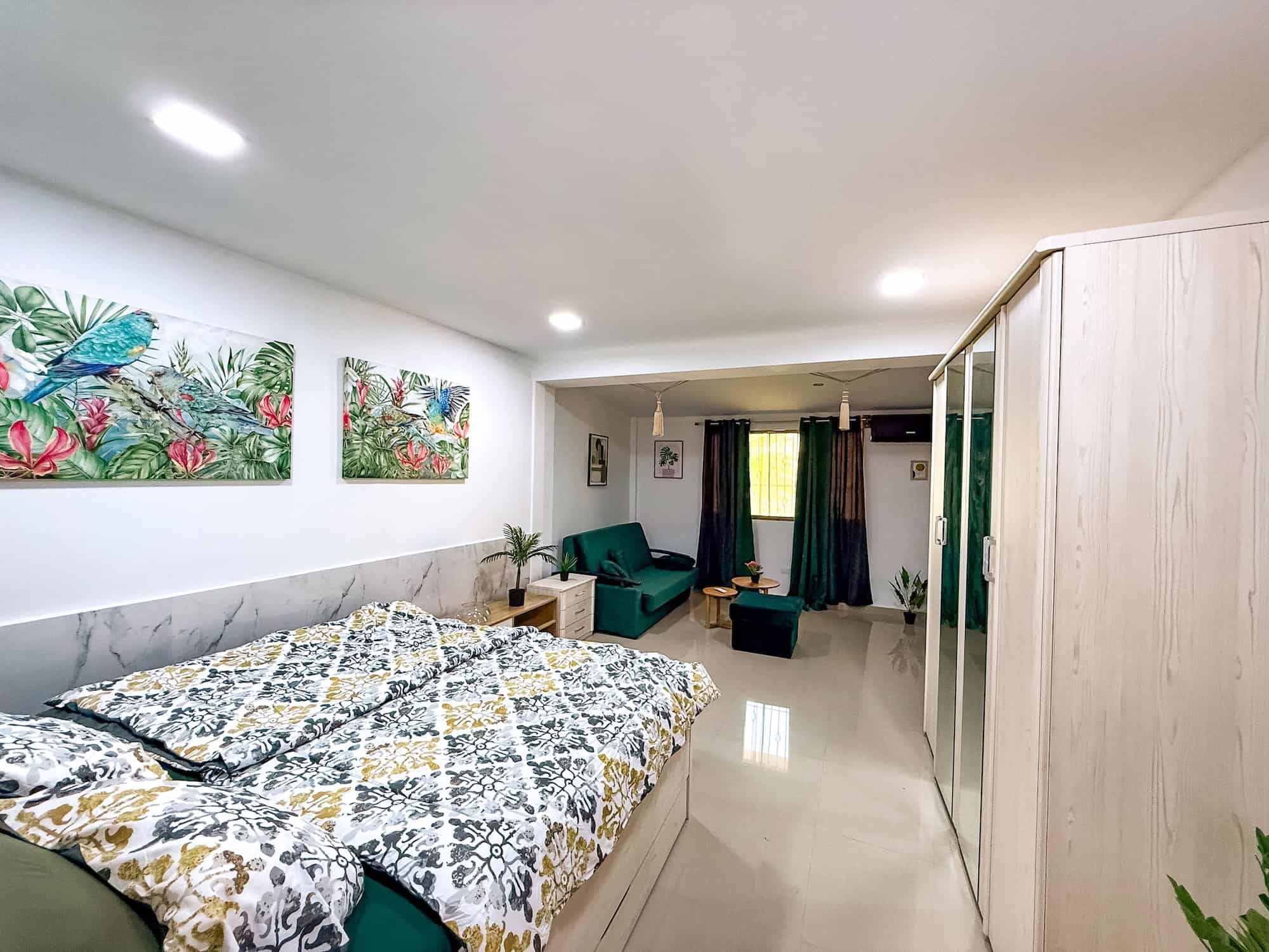 Interiér pokoje v Planet Patanemo s tropickým dekorem a moderním nábytkem.