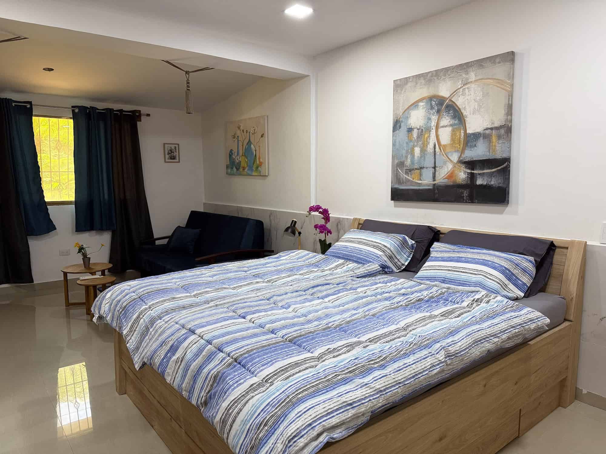 Pohodlný pokoj s postelí, obrazy na stěnách a světlým interiérem v Planet Patanemo. Ideální pro relaxaci a odpočinek.