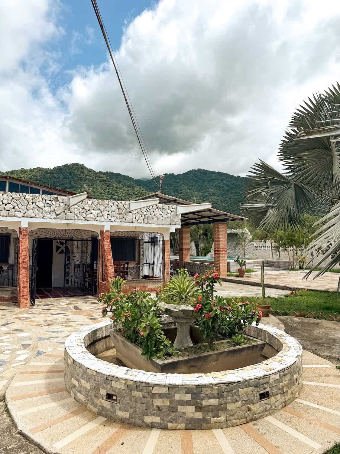 Fontána s květinami v zahradě u domu Planet Patanemo.