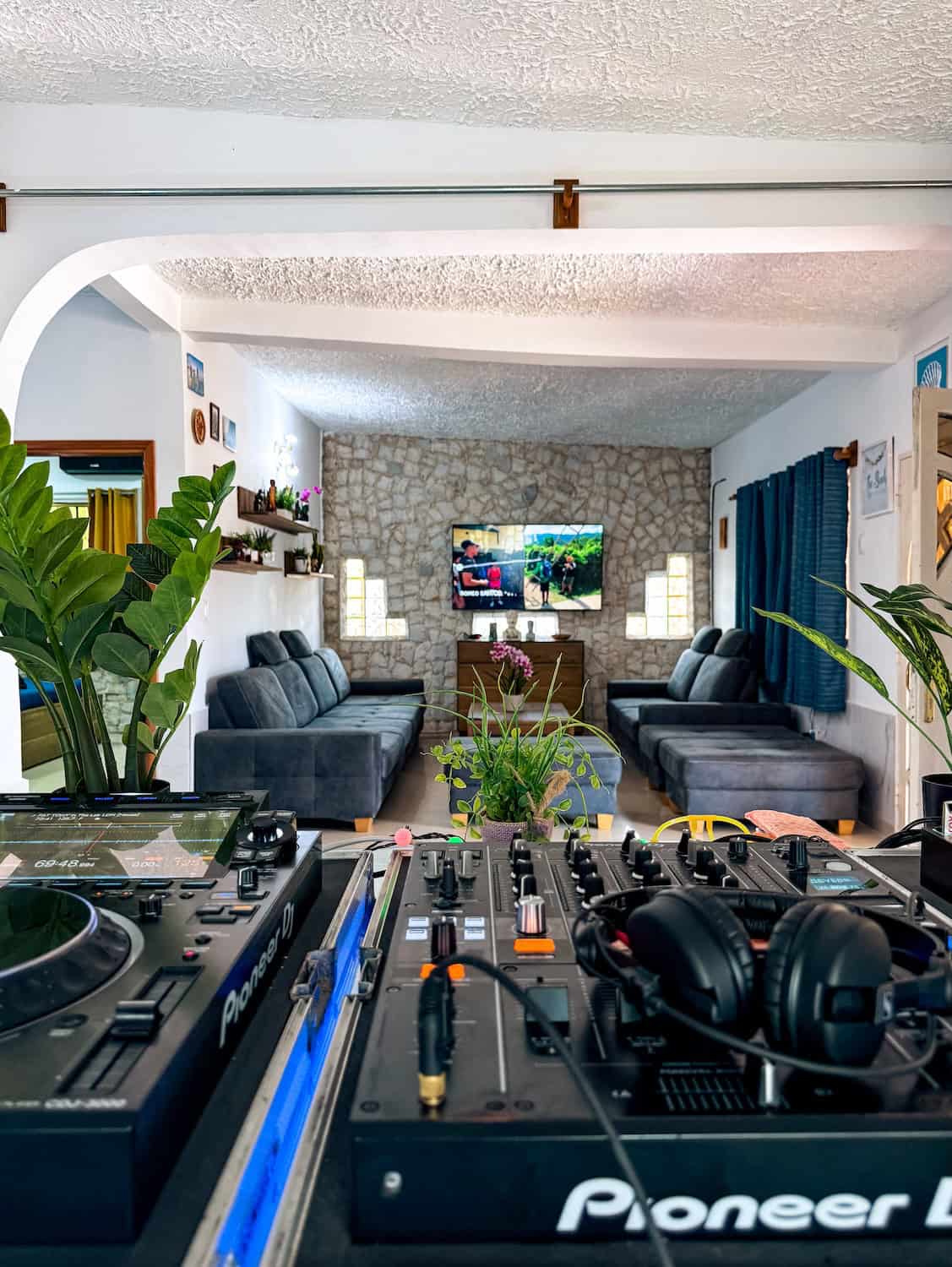 Moderní prostor s pohodlnými sedačkami, DJ vybavením a TV, ideální pro odpočinek v Planet Patanemo.