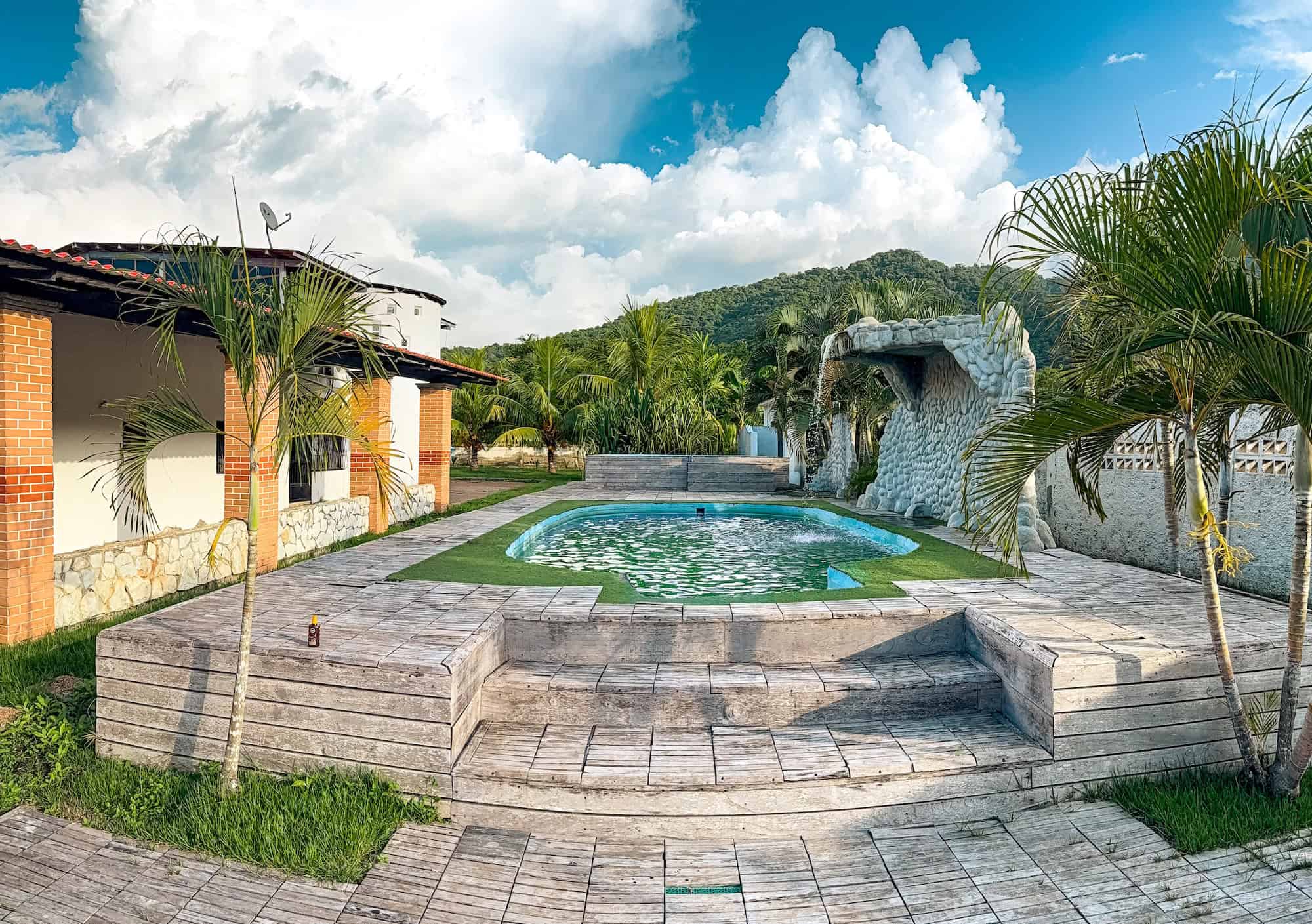 Bazén s přírodními prvky a palmami u Planet Patanemo, ideální pro relaxaci.