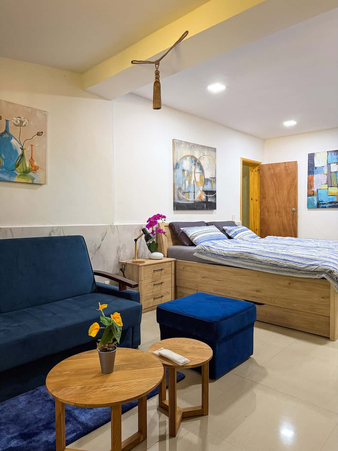 Pokoj v Planet Patanemo s pohodlnou postelí, obrazy na stěnách a útulným posezením.