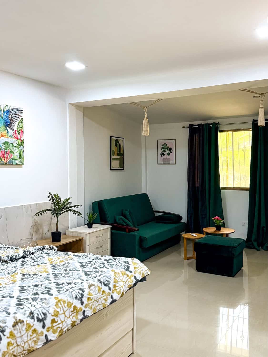 Interiér moderního pokoje s pohovkou, postelí a dekoracemi.