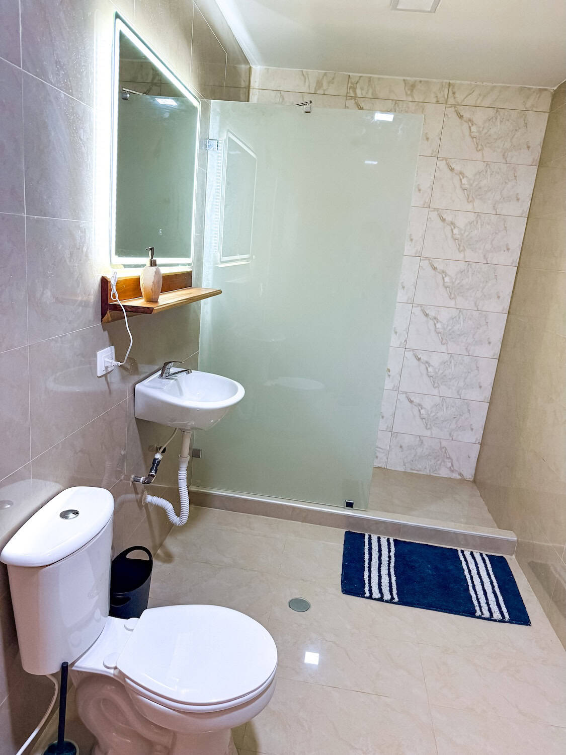 Moderní koupelna s toaletou a sprchovým koutem, ideální pro komfortní hygienu.